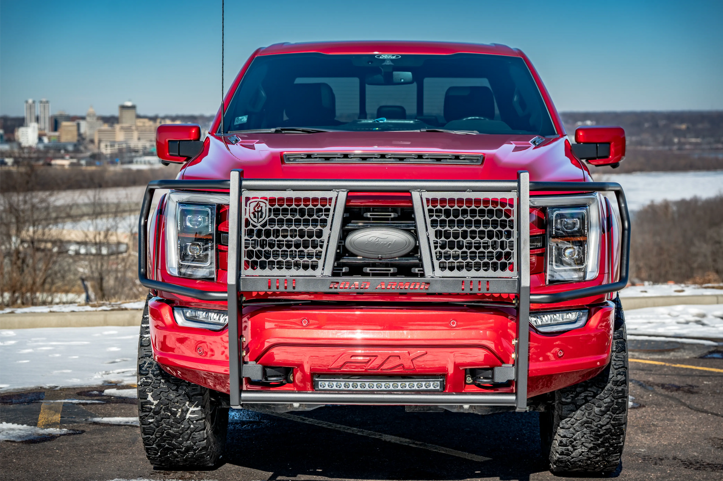 Red Ford F-150 truck with a cityscape in the background