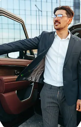 A white jeep parked on a large rock in an outdoor setting, showcasing its rugged tires and off-road capabilities.