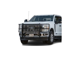 A white jeep parked on a large rock in an outdoor setting, showcasing its rugged tires and off-road capabilities.